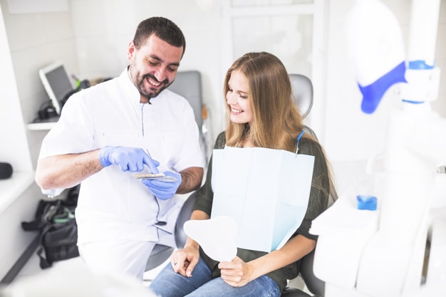 dentista feliz e paciente escolhendo o tom da cor dos dentes osasco sp life min